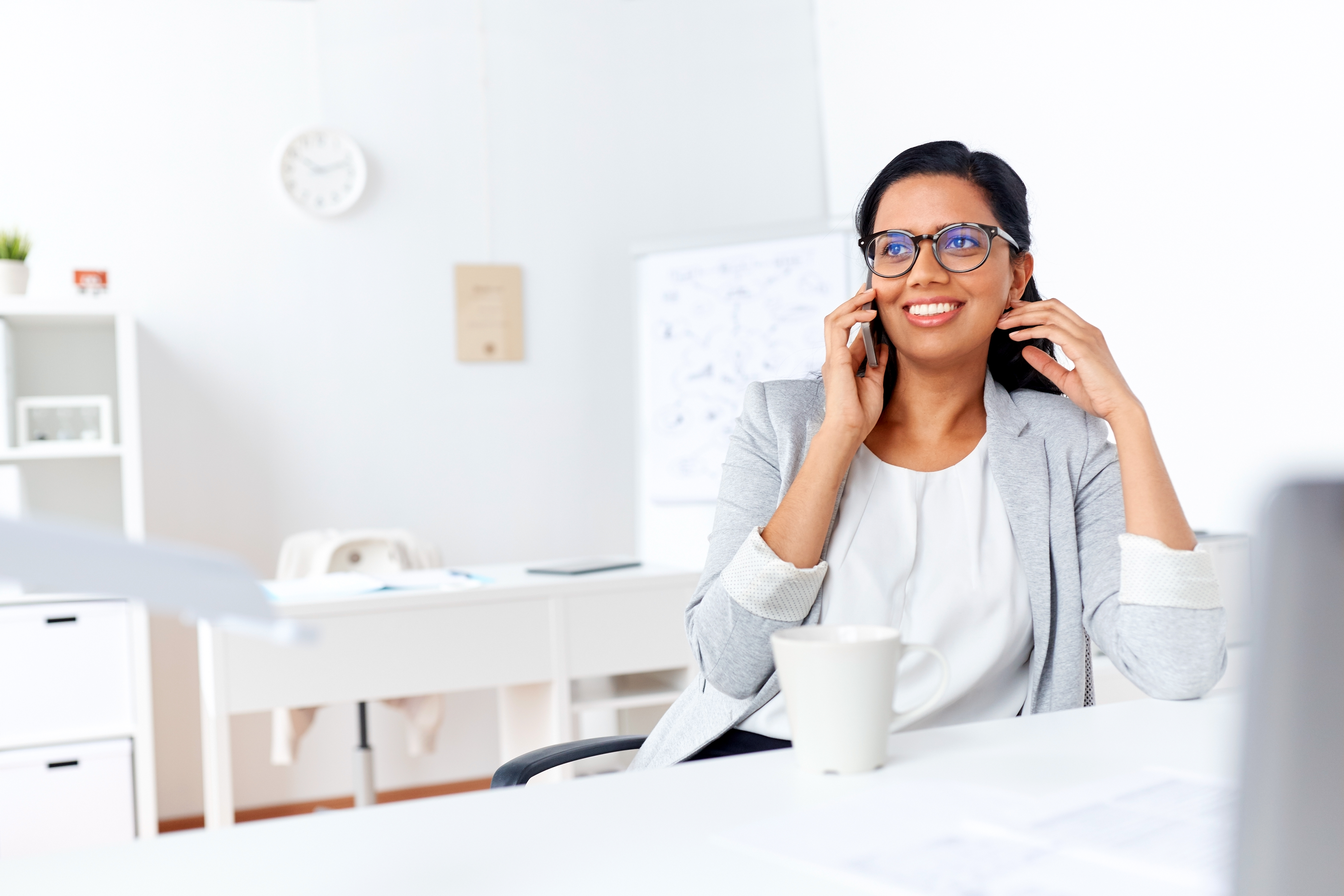 businesswoman calling on smartphone at office business, communication and people concept - happy businesswoman or secretary calling on smartphone at office